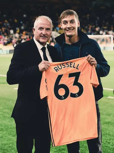 George Russell holding a personalised Wolves shirt