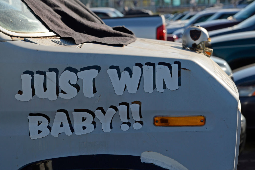 A van parked in the coliseum parking lot has the words 