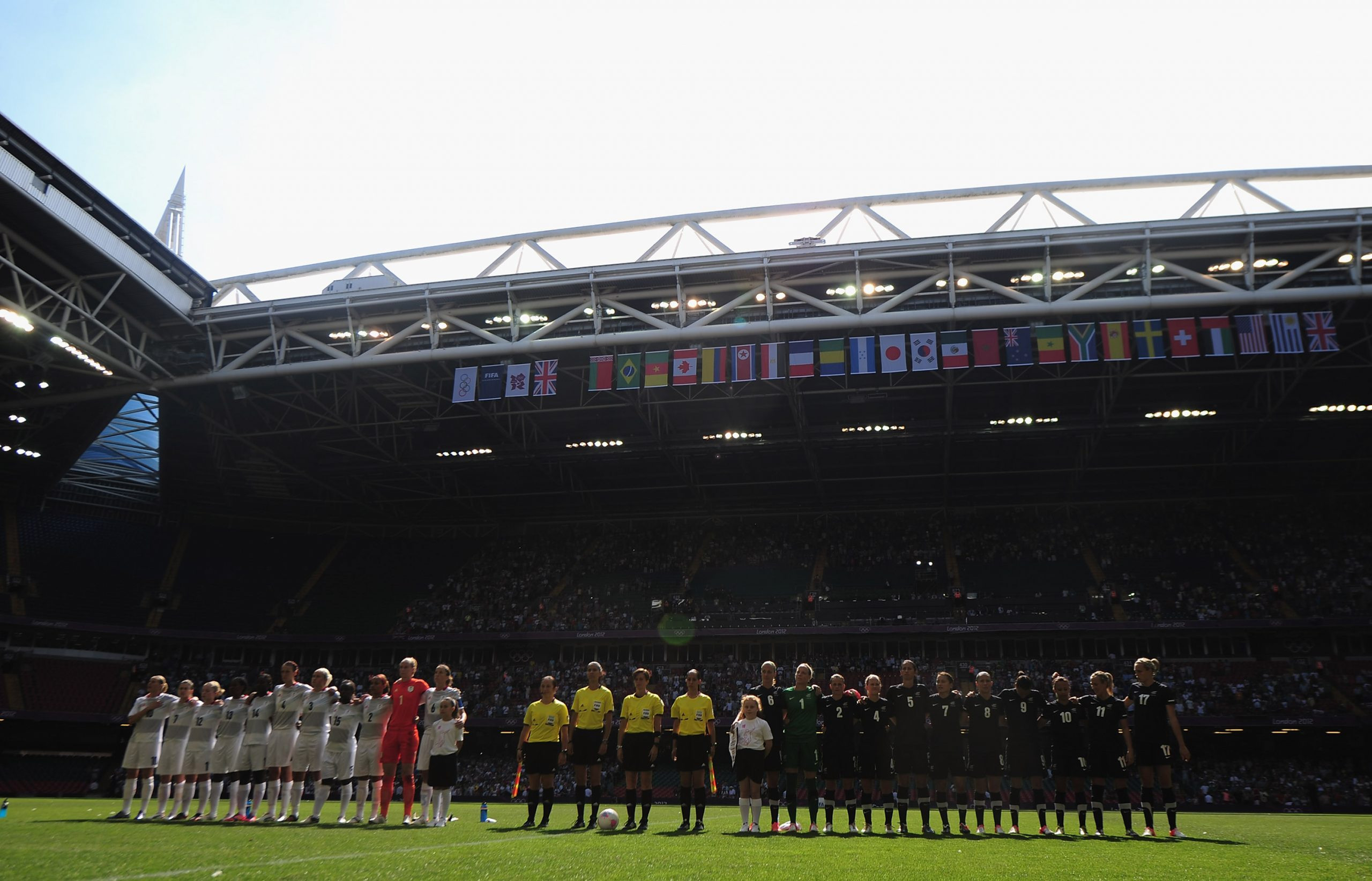The teams of Great Britain and New Zealand line up during a Group E Women’s Football match at Millennium Stadium, reflecting the global appeal and diverse locations of the 2012 Olympics