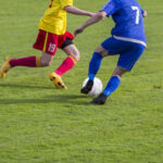 soccer dribbling against an opponent