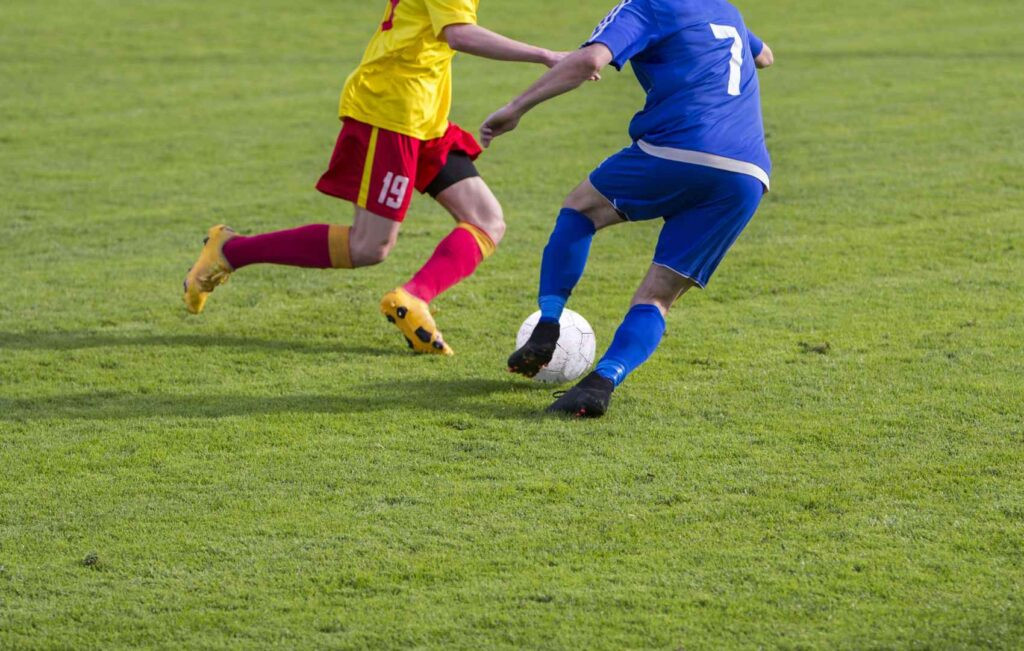 soccer dribbling against an opponent