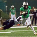 Roswell's Sheldon Evans avoids tackle in high school football game.