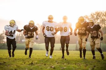 American football players running on the playing field