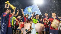 Fans in traditional dress celebrating during the China Football League's Guizhou Village Super League