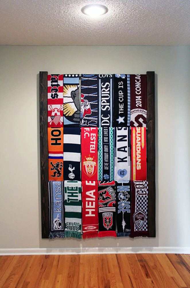 Football scarves draped on a wooden ladder against a wall