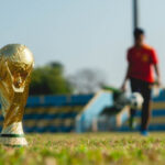 A gold-colored trophy on a grass field during daytime