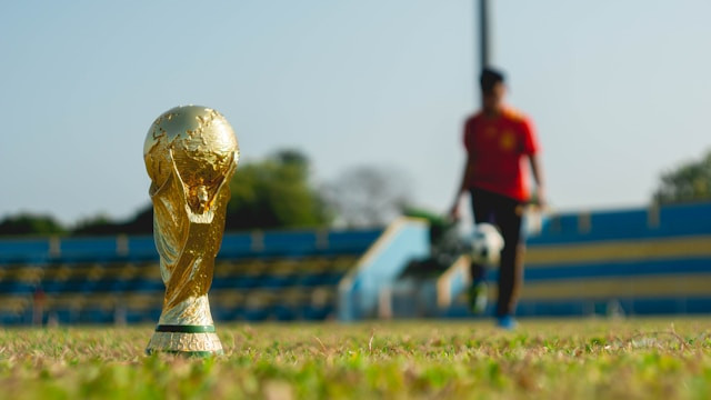 A gold-colored trophy on a grass field during daytime