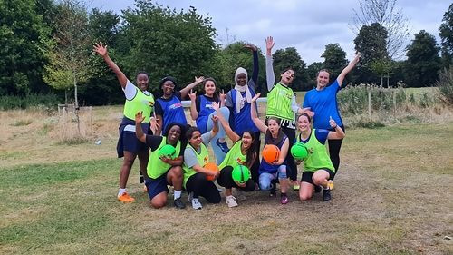A team of women footballers standing together with pride and unity.