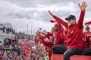 Liverpool manager Jurgen Klopp waves to fans during the bus parade after the Reds