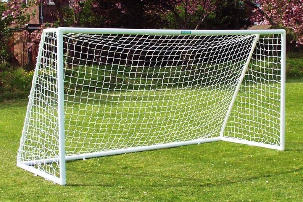 Football goal and net in a garden setting.