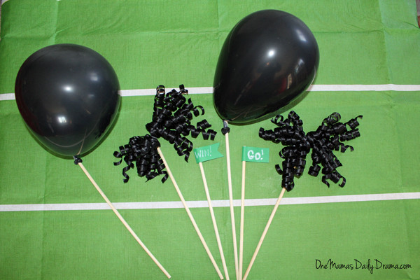 black balloons and streamers tied to dowels