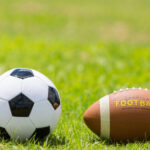 Soccer ball and a football on a field of green grass