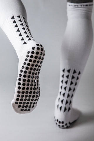A close-up of grip socks demonstrating how they prevent slips and provide extra stability