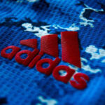 Adidas logo on a replica and player issue shirt