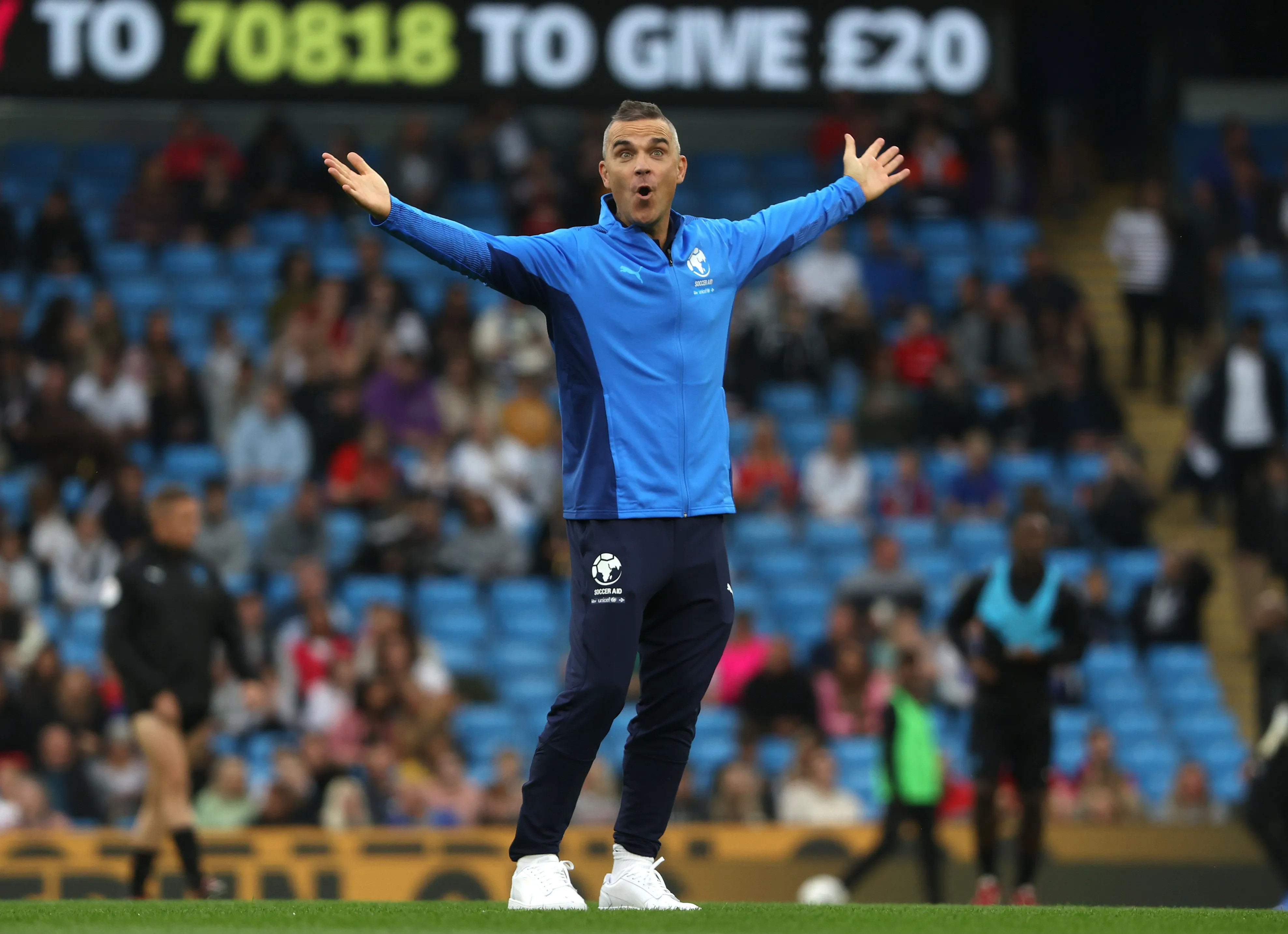 Robbie Williams is a huge football fan and is known for his love of the beautiful game, as captured in this Getty Images photo. His passion extends from supporting his hometown team, Port Vale, to participating in Soccer Aid for charity, showcasing his dedication to the sport and community.