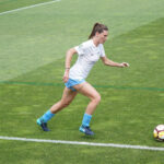 Female soccer player running with the ball