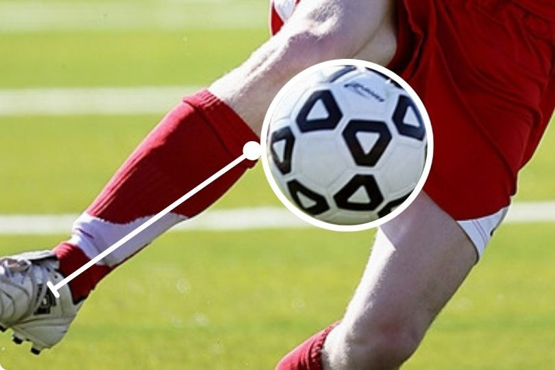 Player in red jersey using first touch, one of the basic fundamental football skill