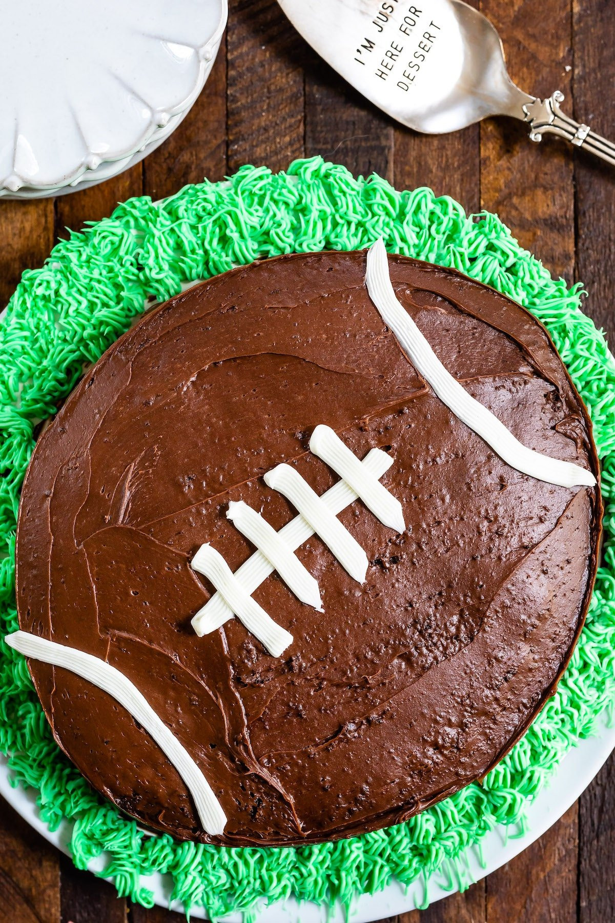 Cake decorated like football with grass on a wood background