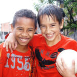 Young children posing with soccer or football in Brazil