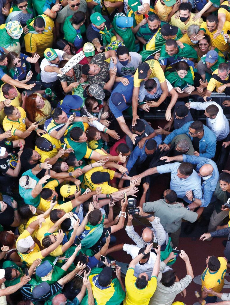 Jair Bolsonaro, in a 2021 rally, with supporters wearing jerseys of the national team, showing how the jersey has become associated with political ideologies.