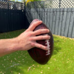 Ring finger over the second lace and pinky under the fifth for football grip
