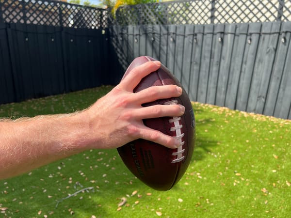 Ring finger over the second lace and pinky under the fifth for football grip