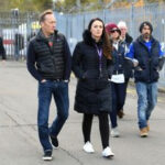 Football pundit Lee Dixon observing tributes for Leicester City chairman Vichai Srivaddhanaprabha before a Premier League match.
