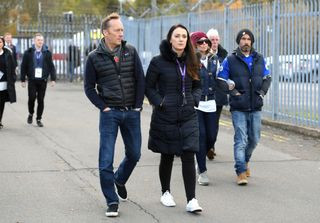 Football pundit Lee Dixon observing tributes for Leicester City chairman Vichai Srivaddhanaprabha before a Premier League match.