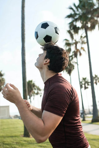 Practicing headers using the head to direct a ball.