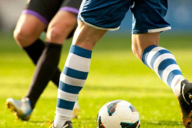 Footballer having his leg treated. Shaved legs can provide quick access for medical staff
