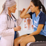 Teen girl soccer player visiting a woman doctor.