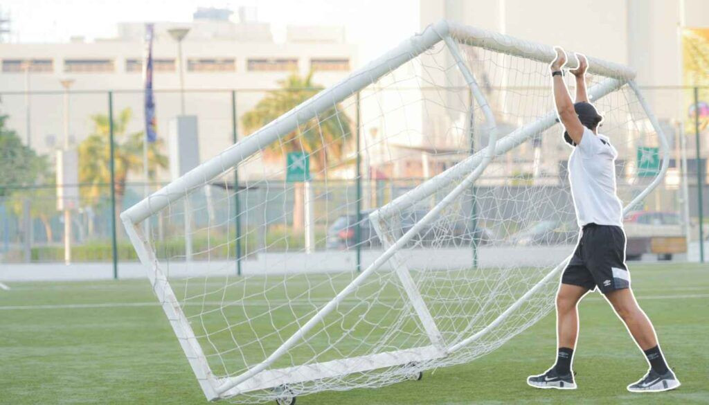 A man moves a movable goal into position - Back of the net!