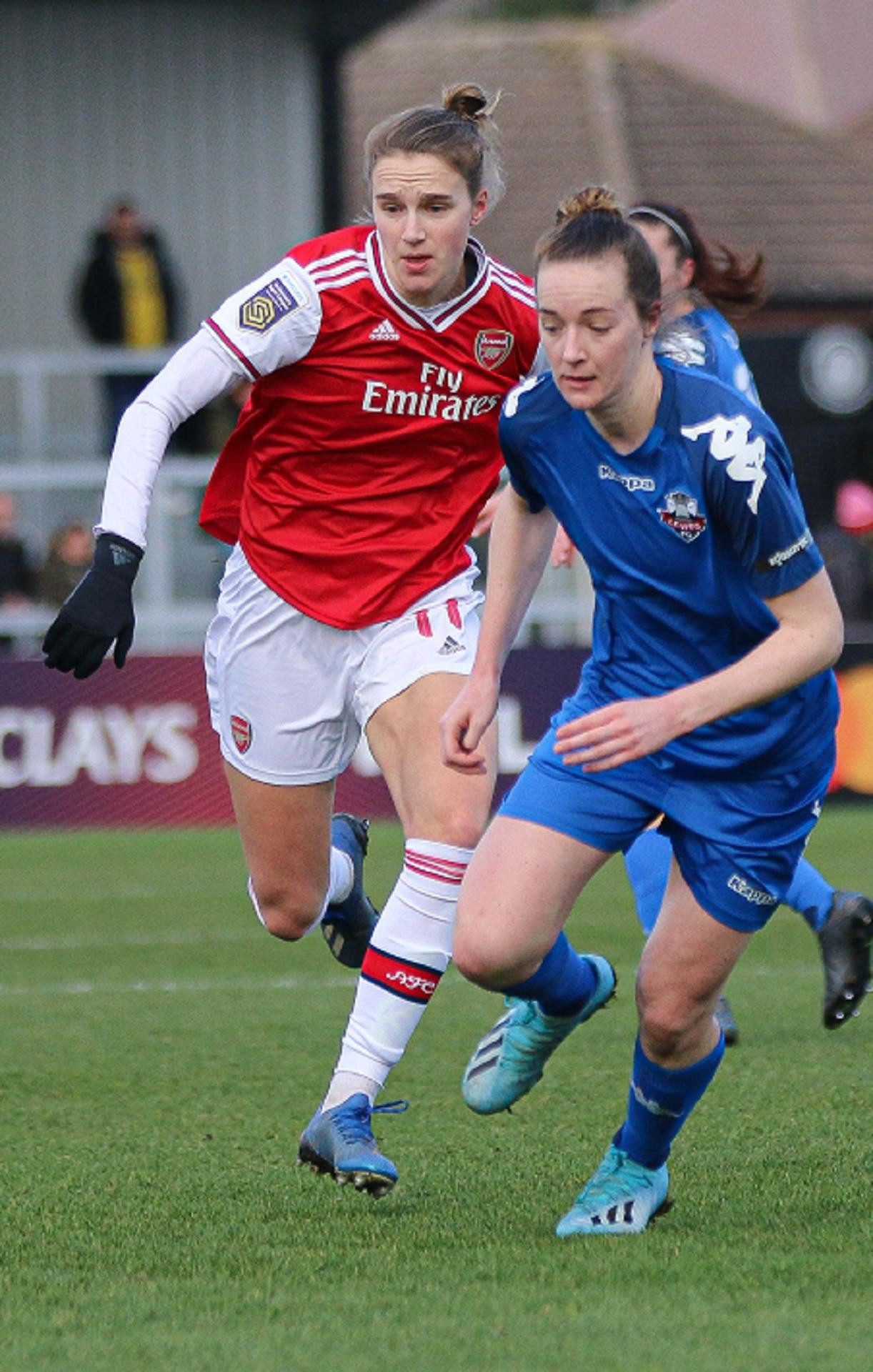 Two soccer players compete for the ball during a match.
