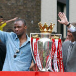Patrick Vieira and Arsene Wenger waving from the open-top bus after winning the Premier League Championship