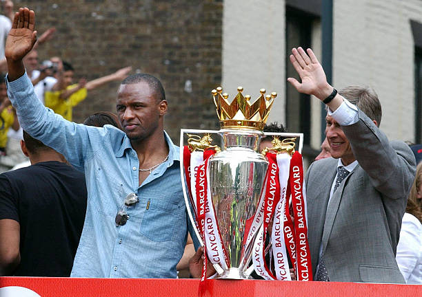 Patrick Vieira and Arsene Wenger waving from the open-top bus after winning the Premier League Championship