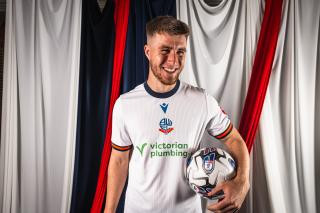 George Thomason wearing Bolton Wanderers 2024/25 home kit