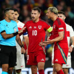 Referee Rohit Saggi speaks to Wales pair Aaron Ramsey and Ethan Ampadu in the goalless Nations League draw with Turkey