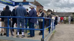 A long line of between 30 and 40 people queuing at the entrance to Southend United