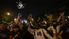 Getty Images A group of celebrating football fans with the Arc de Triomphe visible in the background