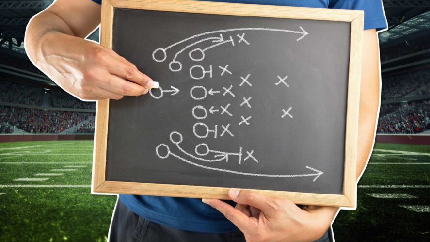 An American Football coach holding a tactics board
