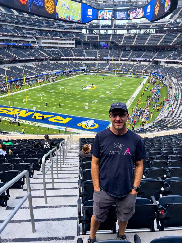 Dan Brewer, owner of UltimateSportsRoadTrip.com, stands at his seats in SoFi Stadium prior to an LA Rams game
