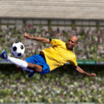 A football player kicks the ball.