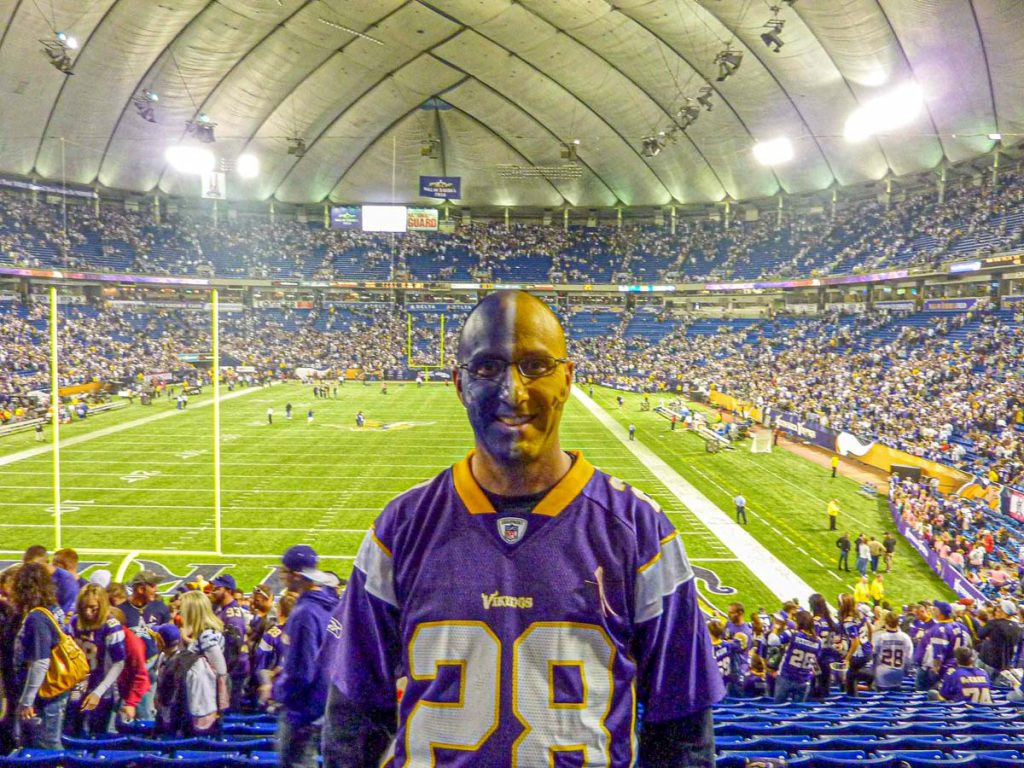 Dan Brewer, of the Ultimate Sports Road Trip website, has his face painted Vikings colors before a game at the old Metrodome