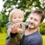 A middle-aged man with his son in the park.