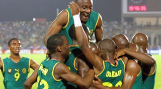 Cameroon players celebrating in the sleeveless home kit