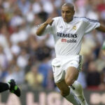 Roberto Carlos dribbles with the ball.