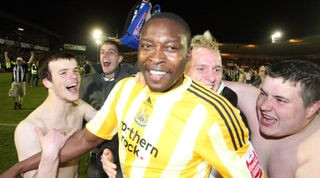 Shola Ameobi celebrates with fans in the vomit-inducing Newcastle away kit