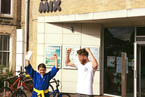 Two people celebrating outside the front of the Mix