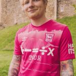 a man is wearing a pink shirt that says tour on it